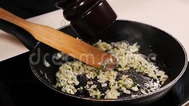 在炒洋葱、大蒜和草药中，厨师从胡椒瓶中加入胡椒粉