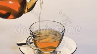 特写镜头将茶倒入透明的玻璃杯中