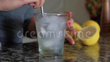女人用勺子搅拌<strong>一杯柠檬水</strong>和冰块