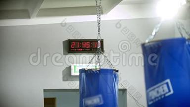 健身房墙上的计时器-前面挂着打孔袋