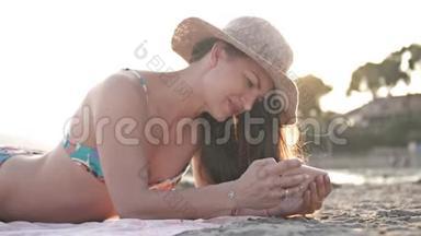 女孩使用智能手机在海滩挥手打招呼在视频聊天。 在暑假旅行中享受海滩度假的乐趣