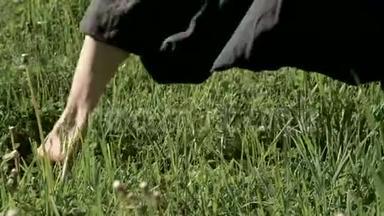一个练习者在户外草地上`腿的特写。 在气功练习中赤脚穿越。 a的概念
