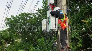 专业电工在电杆上进行安装工作.. 专业设备电工，在危险公司工作