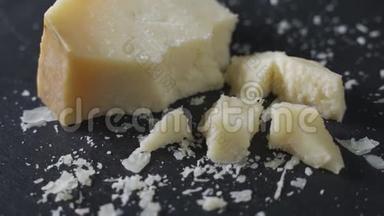 黑石盘上的硬味帕尔马干酪。 板块旋转，特写