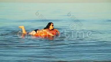 一位身穿泳装的黑发女子在靠近海岸的海域游泳