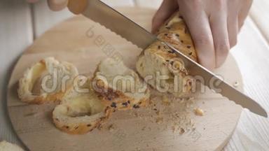 用<strong>面包刀</strong>在<strong>厨房</strong>的木切割板上切割法国<strong>面包</strong>