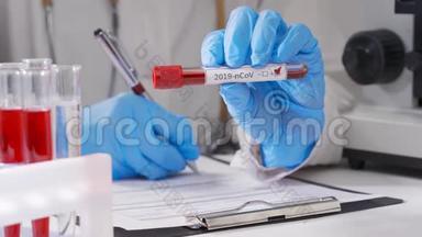 冠状病毒血液检测，带防护手套的女实验室技术人员在医院检测血样