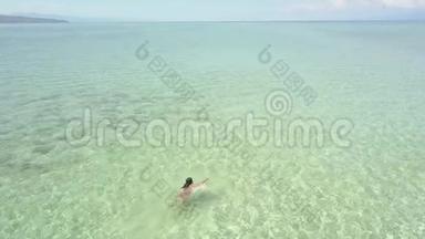 一位游客在菲林岛一片清澈的海洋里游泳的鸟瞰图。