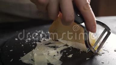 帕尔马干酪成分，在木切割板上.. 一只手拿着刀，折断几块来细细品味