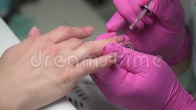 美甲美容师用闪光指甲油覆盖客户`指甲