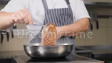 男厨师用钳子夹鸭胸的特写镜头。 慢动作。 煎锅上炸出美味的鸭肉