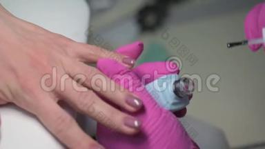 美甲美容师在指甲油上用清晰`保护指甲
