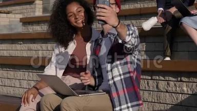 微笑的青少年夫妇玩得开心，在智能手机相机上制作自拍照片。