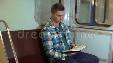 一个年轻人在地铁火车上看书。 旧地铁车