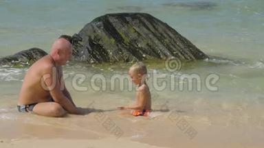 <strong>父子</strong>一家人在<strong>海滩</strong>上的清澈海水中休息