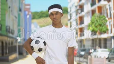 自信的青少年足球运动员带球看镜头，<strong>挑战</strong>