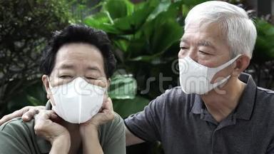 戴口罩的中国老夫妇保护病毒不受爆发污染的威胁