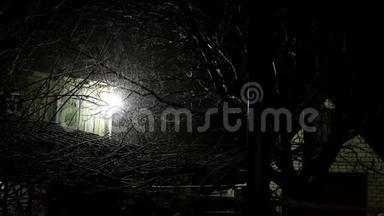 旧房子后院下雪，夜晚灯火通明。 神秘的冬季乡村景观.. 中期计划。