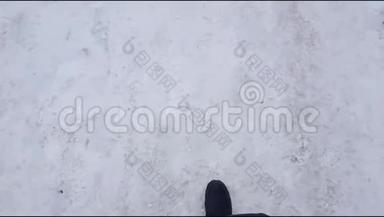 俯视图，一个男人在滑滑的道路上<strong>小心翼翼</strong>地穿过雪地的自拍。 冬天在冰上小心驾驶
