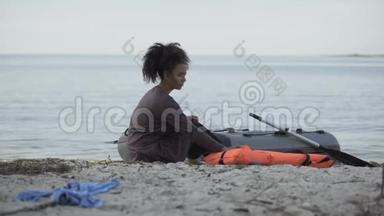被冻死的少女坐在海边的小船旁，遇难的难民<strong>幸存</strong>者