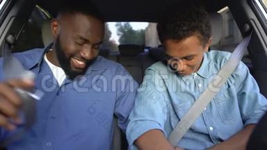 黑人少年和快乐的父亲微笑着在车上系<strong>安全带</strong>