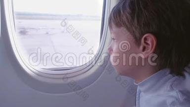 飞机起飞时，男孩望着窗外。 侧视。