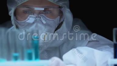 戴防护眼镜和呼吸器的女科学家，<strong>取样</strong>液体，实验室