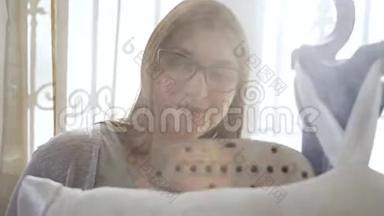 一个戴眼镜的年轻女人用蒸笼抚摸东西。 烫东西的过程