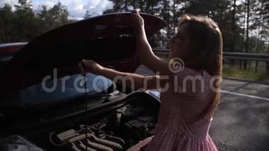 金发女郎打开一辆红色汽车的引擎盖，试图弄明白是什么在<strong>赛道</strong>上抛锚了。4K慢Mo