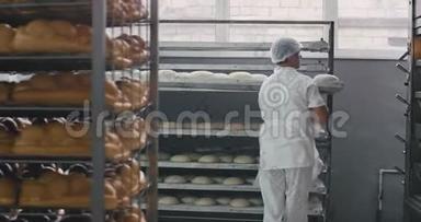 在一个大<strong>面包</strong>店里工作，两个专业的工人把生<strong>面包</strong>装在烤箱里，另一个工人装在烤箱里