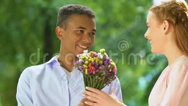 黑少年男孩给白种人女孩送野花，多民族关系