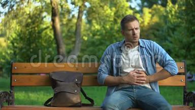 男人在长椅上放松，突然感觉到强烈的胃痛，<strong>胃炎</strong>问题