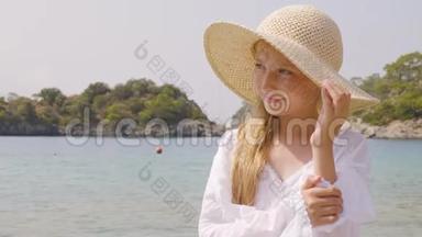 蓝色海洋背景上戴草帽的可爱少年<strong>女孩</strong>肖像。 在夏季行动。 美丽的少女<strong>装扮</strong>