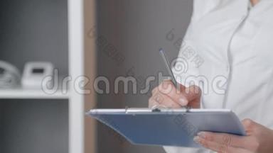 一名身穿白色外套、<strong>手拿</strong>蓝色<strong>文件</strong>夹的护士的特写，并在医务处记录信息
