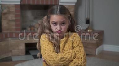 一个穿着芥末毛衣的愤怒的白种人女孩的特写脸，交叉的<strong>双手</strong>放在<strong>胸</strong>前。 不满意的孩子摇着她