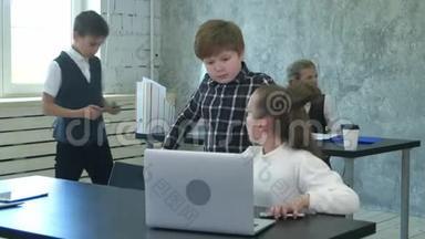<strong>两个小孩子</strong>在现代办公室讨论和工作笔记本电脑