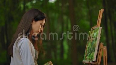 一个女孩在森林中画一幅<strong>风景画</strong>的中等肖像轮廓