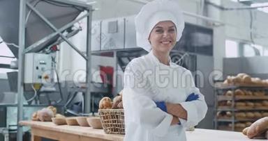 可爱的面包师女人在镜头前直视和微笑的<strong>大型</strong>商业厨房，工业<strong>机器</strong>上