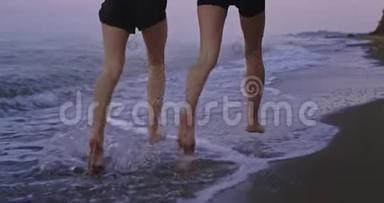 两位运动的女士在海边一起跑步的细节有一个健康的生活方式。 缓慢的动作