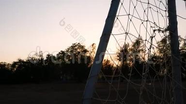 在公共体育场有日落灯光背景的足球球门。