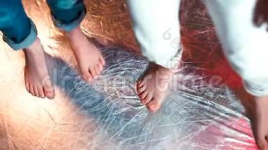 在闪亮的地板上做舞蹈动作的孩子们的脚的特写。