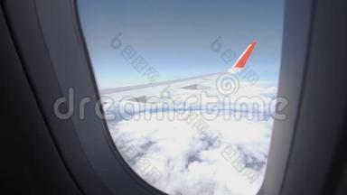 飞机飞行。 飞行在云层之上的飞机的机翼。 从平面的窗口查看.. 飞机。