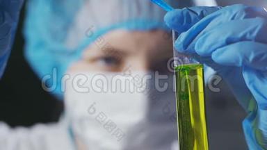 在科学实验室研究液体的女科学家。 接近做实验室研究的女科学家。