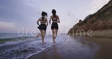 令人惊叹的海滩景色，两位漂亮的女士在早上一起跑步，呼吸新鲜空气，享受海景。 慢慢慢慢