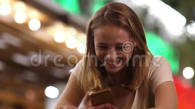 酒吧里的一个开朗的女人在手机上读着有趣的信息。