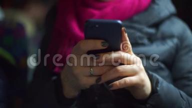 一位乘坐<strong>公共交通工具</strong>的妇女手里拿着智能手机