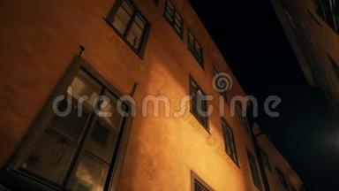 旧城区欧洲夜间街道上的公寓楼。 斯堪的纳维亚的窗户。