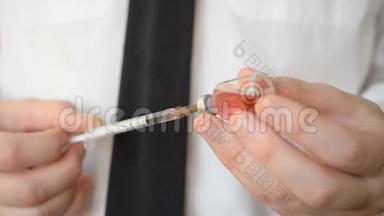 `医生的手在胰岛素注射器中注射抗埃博拉病毒和热带热的红色疫苗