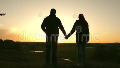 旅行者男女两手相握，`日落时欣赏风景。 情侣旅行者带背包旅行