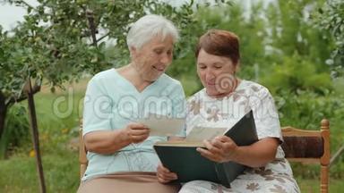 老年妇女在户外相册中观看照片